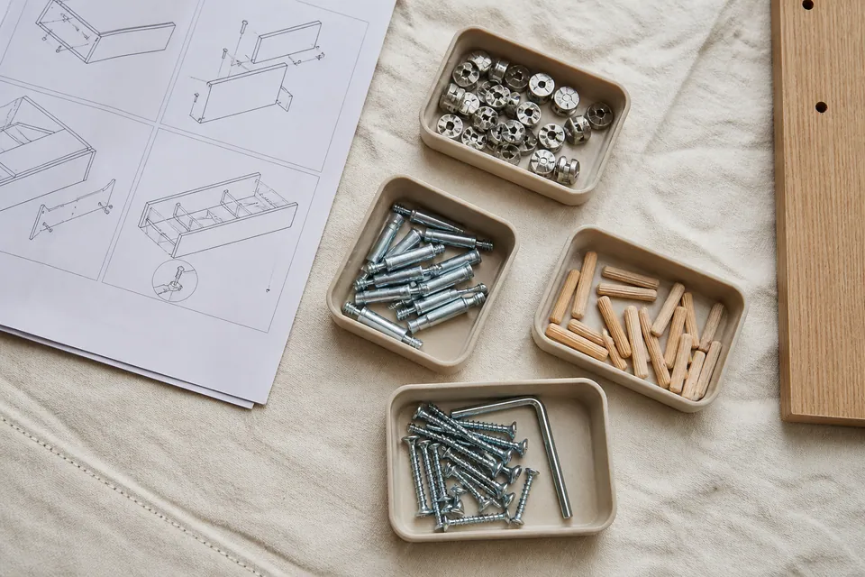 Cam locks dowels and screws organised separately before furniture assembly